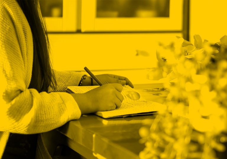 woman writing notes in notebook