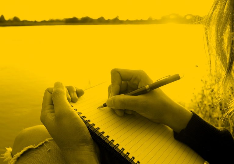 person writing in notebook